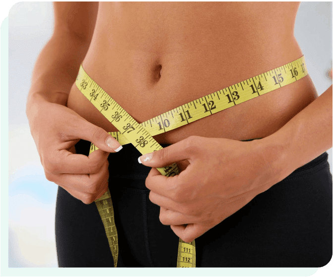 A woman is measuring her waist with a tape measure.