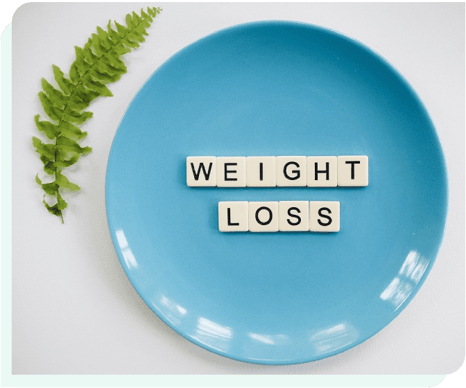 A blue plate with the words weight loss spelled out in scrabble tiles.