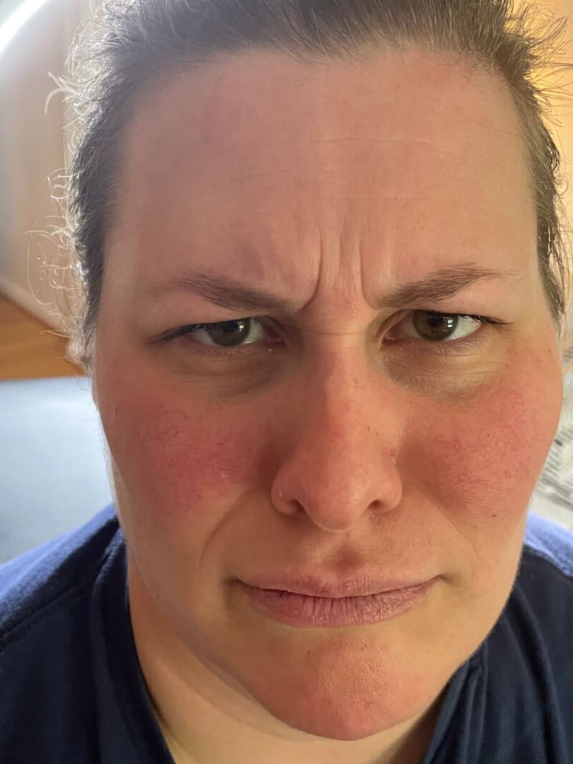 A woman with frowning face and no makeup.