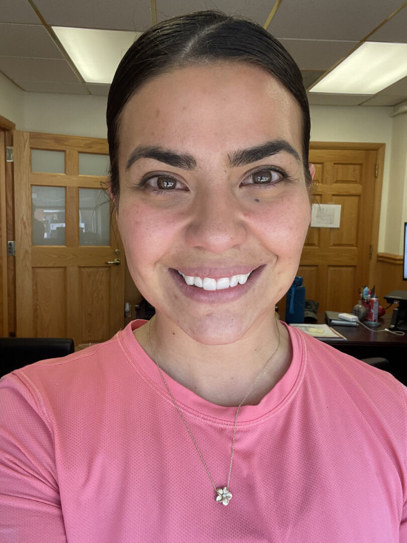 A woman in pink shirt smiling for the camera.