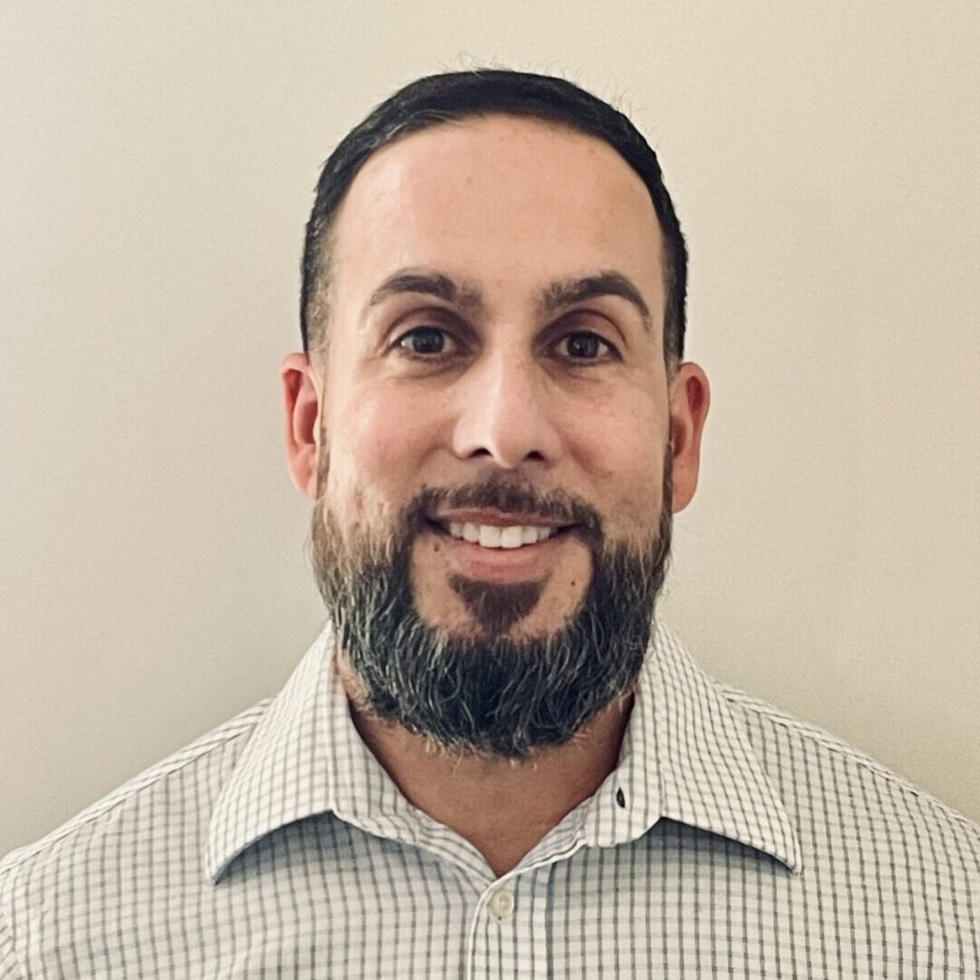 A man with a beard and mustache wearing a shirt